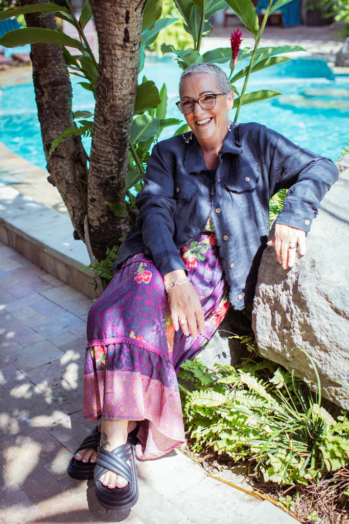 Taleeta - Indigo Jacket - Purple Hibiscus Jungle Dress - Facing Front Left - Sitting - Fullshot